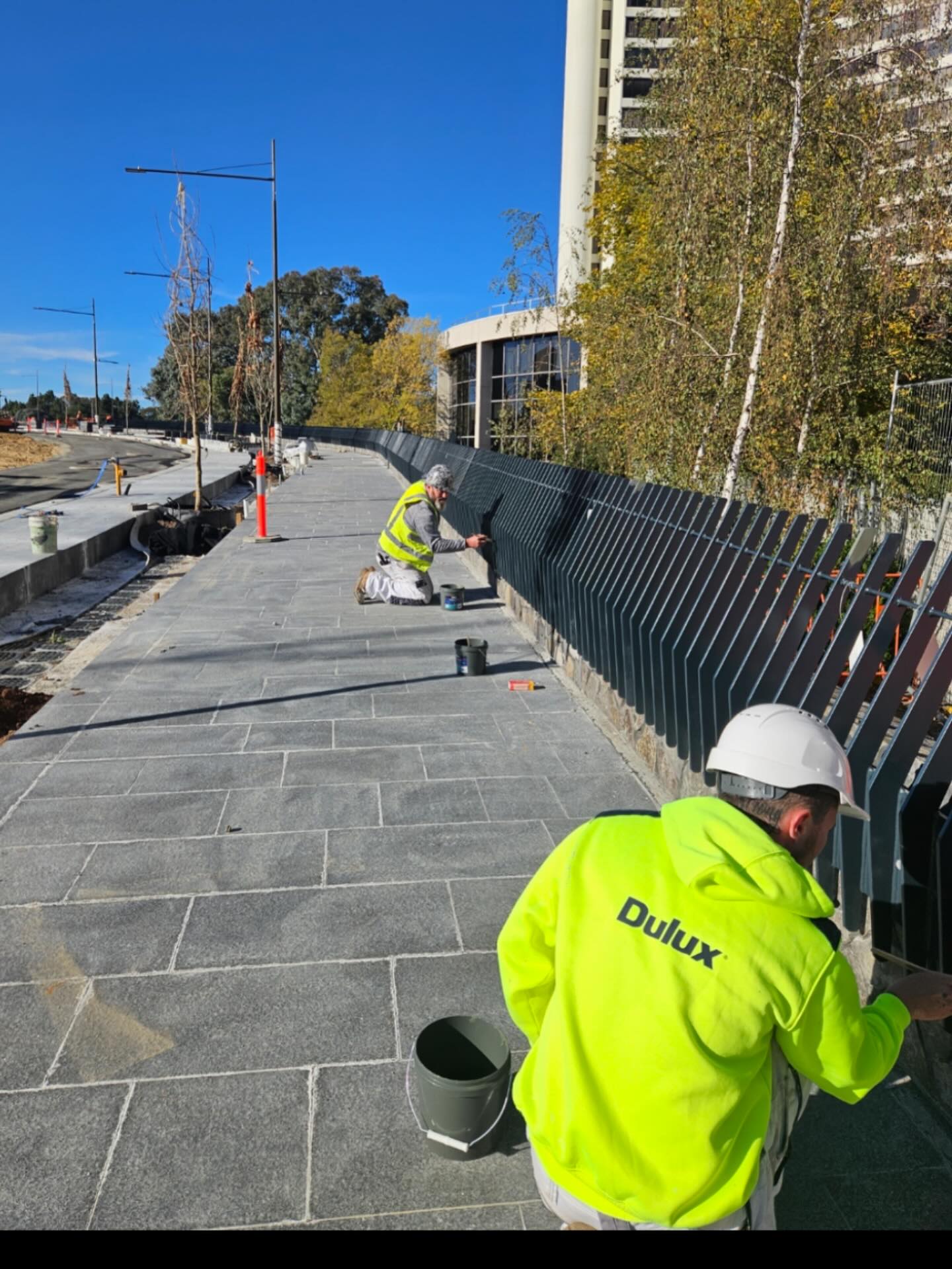 Hodgson and Sons painters coating a commercial fence in Canberra